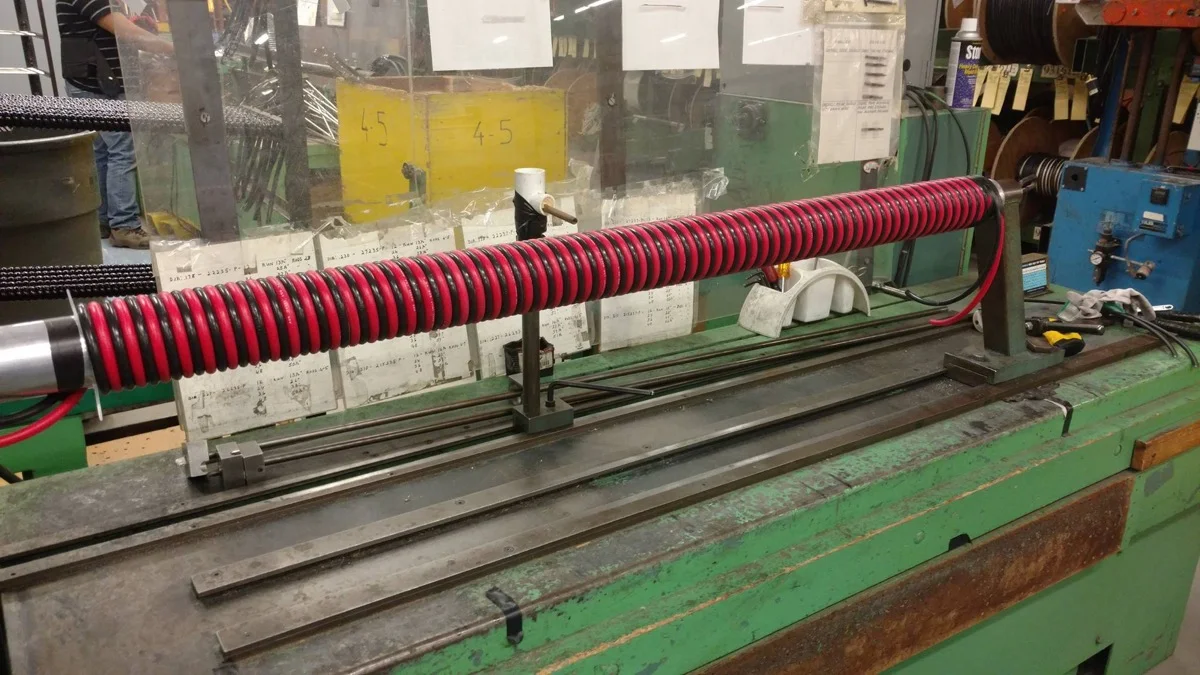 Heavy gauge red and black coiled battery cable on a winding mandrel