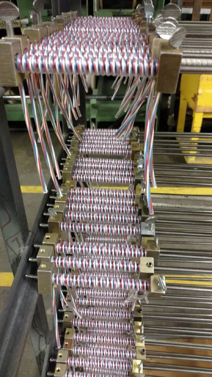 Red, white, and blue striped coiled cords on winding mandrels