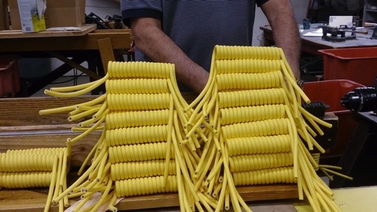 Finished batch of yellow coiled cords bundled on the bench