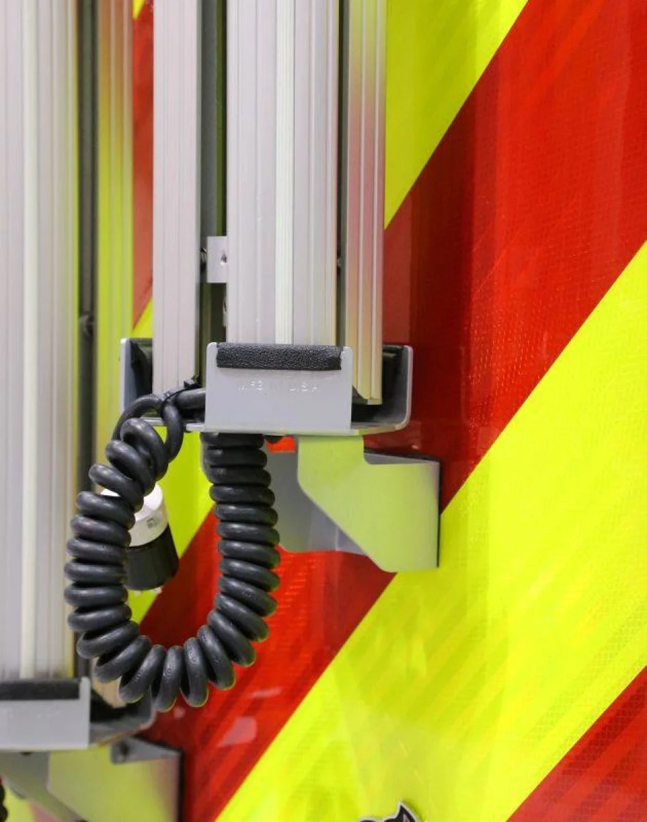 Gray retractile cord in use on emergency vehicle equipment