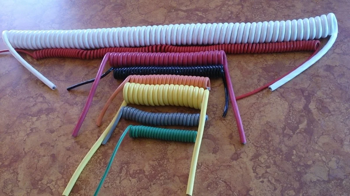 Retractile coil cords in white, red, black, yellow, gray, and green jackets