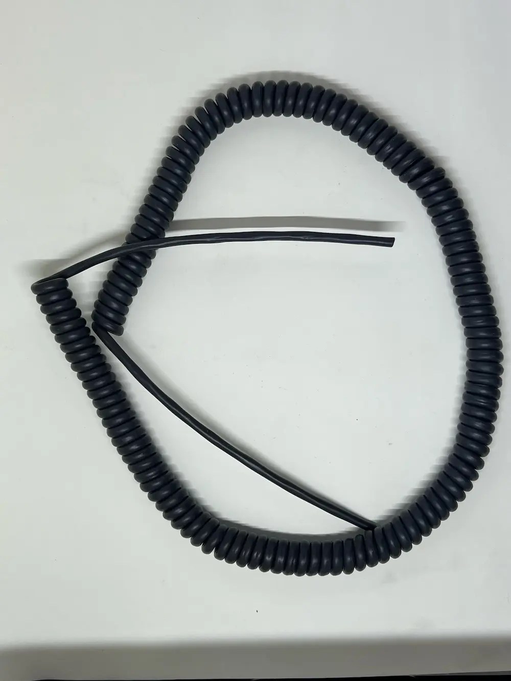 Autac retractile power cords in red and black coiled configurations, shipped to Wisconsin manufacturers