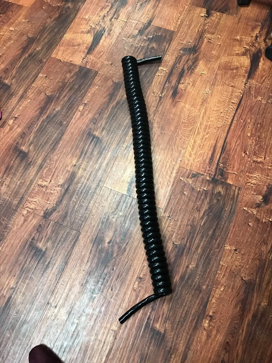 Black retractile cord stretched to its full extended length